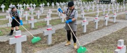 młodzież sprzątająca cmentarz wojskowy